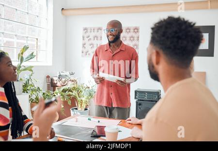 Groupe de divers hommes d'affaires ayant une réunion dans un bureau moderne au travail. Jeune homme d'affaires afro-américain heureux portant des lunettes faisant un Banque D'Images