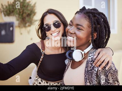 Les meilleurs amis stylés s'amusent et prennent un selfie en plein air. Deux amies multiethniques passent du temps ensemble et prennent des photos sur les réseaux sociaux Banque D'Images