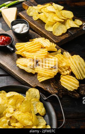 Croustilles aromatisées au vinaigre de sel sur fond de table en bois foncé Banque D'Images