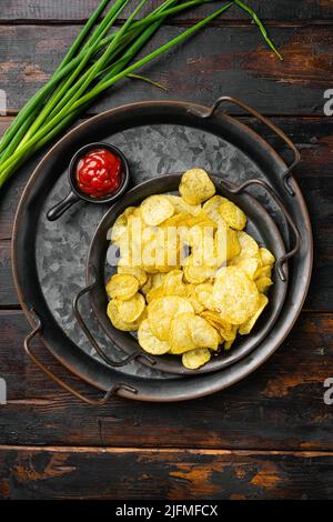 Croustilles aromatisées au vinaigre de sel sur fond de table en bois foncé, plan de dessus Banque D'Images