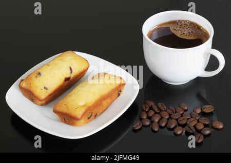 Cupcake rectangulaire aux pépites de chocolat et tasse de café sur table noire Banque D'Images