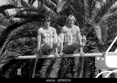 ARCHIVE PHOTO: Carlo THRAENHARDT aura 65 ans sur 5 juillet 2022, Dietmar MOEGENBURG (à gauche) et Carlo THRAENHARDT, Allemagne, High Jumper, High Jump, privé, Asseyez-vous dans des supports d'avant-bras sur un tremplin à la piscine, au camp d'entraînement de haut cavalier à Estepona Espagne, 24,03. 1984, enregistrement noir et blanc. Banque D'Images