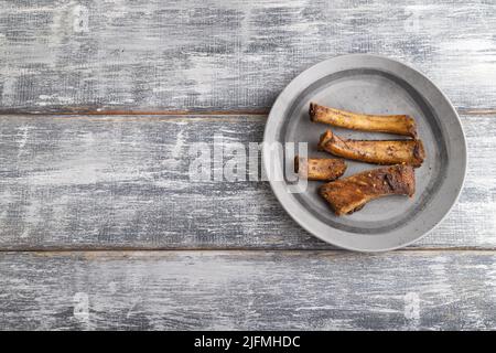 côtes de porc sur une assiette en bois sur fond de bois gris. Vue de dessus, plan d'affichage, gros plan, espace de copie. Banque D'Images