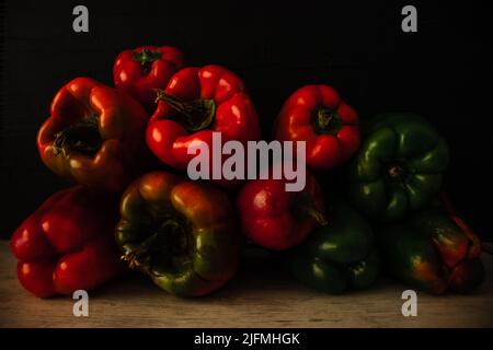 Paprika rouge vert orange frais sur fond noir Banque D'Images