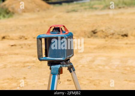 L'entrepreneur du chantier utilise un équipement de construction laser à tige de niveau Banque D'Images