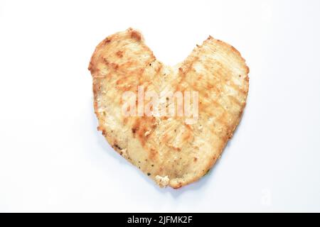 le steak de poulet grillé ressemble à un cœur sur du bacille de bois blanc Banque D'Images