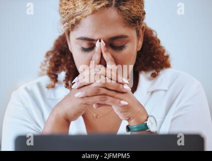 Gros plan d'une femme d'affaires de course mixte souffrant d'un mal de tête travaillant sur un ordinateur portable seul au travail. Femme hispanique stressée pendant son travail. Bossage femelle Banque D'Images