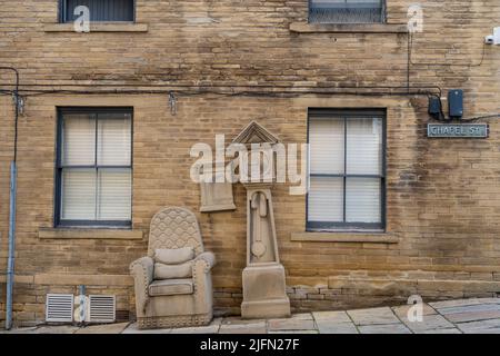 Grandad’s Clock and chair mobilier en pierre sculpture de Timothy Shutter, situé dans Chapel Street dans la région de Little Germany de la ville de Bradford, Royaume-Uni. Banque D'Images