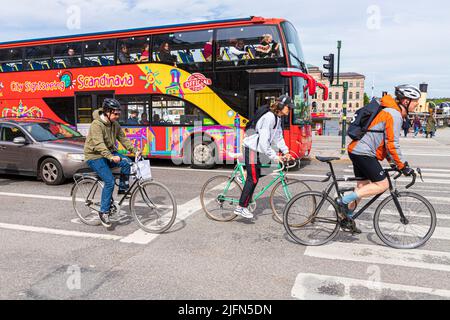 Cyclistes et un bus touristique à Skeppsbron, centre de Stockholm, Suède Banque D'Images
