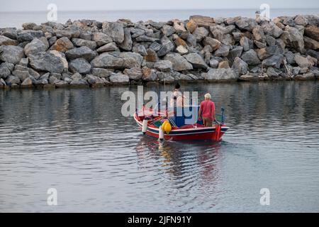 Un pêcheur avec sa fille se dirigeant vers la mer avec leur bateau de pêche Banque D'Images