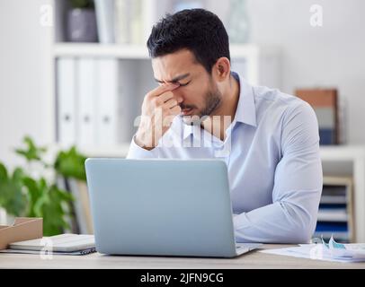 A souligné l'homme d'affaires asiatique travaillant sur un ordinateur portable. Un professionnel frustré a été stressé lorsqu'il travaille en ligne. Homme anxieux à la recherche de solution pendant Banque D'Images