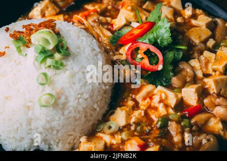 Un gros plan de poulet kung pao avec du riz dans un bol Banque D'Images