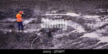 Kiev, Ukraine, 17 octobre 2018: Travailleurs dans la boue d'un chantier de construction au stade de l'excavation; construction d'un supermarché AUCHAN Banque D'Images