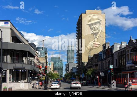 Montréal, Canada - 3 juillet 2022 : la rue Crescent à la mode avec la fresque du légendaire chanteur/compositeur Leonard Cohen sur le côté du bâtiment. Banque D'Images