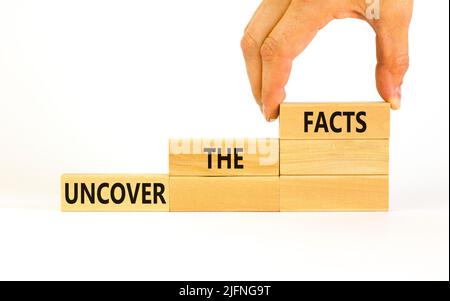 Uncover the facts symbol. Concept words Uncover the facts on wooden blocks on a beautiful white table white background. Businessman hand. Business and Banque D'Images