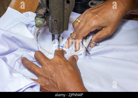 Broder des numéros thaïlandais sur une chemise d'étudiant sur une vieille machine à coudre Banque D'Images