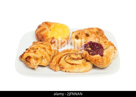 Sélection de mini pâtisseries danoises sur une assiette isolée du blanc Banque D'Images