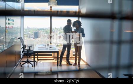Des collègues multiraciaux discutant de la paperasserie dans un bureau moderne. Banque D'Images