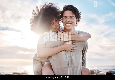 Portrait d'un jeune couple mixte de course appréciant une journée à la plage à l'air heureux et dans l'amour. Portrait d'un jeune couple mixte de course appréciant une journée à Banque D'Images