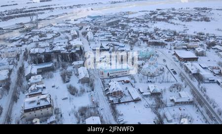 Vue aérienne de la zone industrielle d'une petite ville en hiver. Attache. Arbres et bâtiments enneigés. Banque D'Images