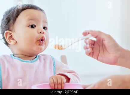 La pout la plus coupée. Prise de vue d'une femme méconnue qui allaite sa petite fille à la maison. Banque D'Images