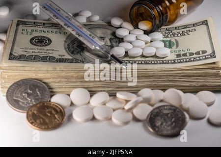 Pile de l'argent américain avec des médicaments, des pilules et un thermomètre clinique sur pile de l'argent en dollars Banque D'Images