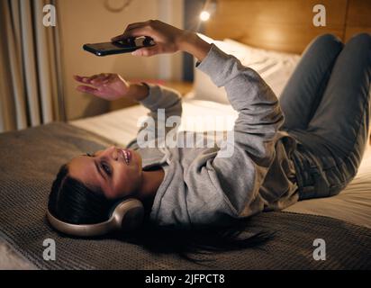 Je ne pouvais pas dormir Prise de vue rognée d'une jeune femme attirante effectuant un appel vidéo en étant allongé dans sa chambre à la maison tard dans la nuit. Banque D'Images