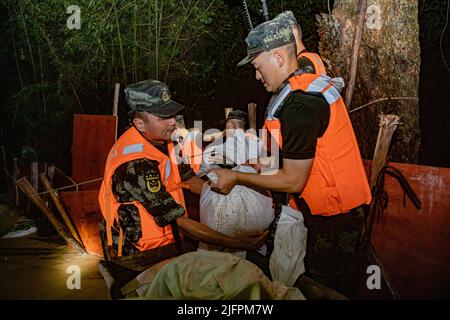 BEIHAI, CHINE - le 4 JUILLET 2022 - des policiers et des soldats armés utilisent des sacs de sable, des piquets et des planches de bois pour construire un barrage pour bloquer la brèche à Beihai Banque D'Images
