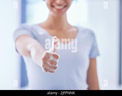 Une mousse oui de moi. Photo d'une femme méconnaissable montrant un pouce de savon tout en nettoyant son appartement. Banque D'Images