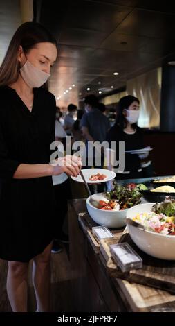 Une femme au buffet servant la ligne W Hotel Kitchen Table Restaurant Bangkok Thaïlande Banque D'Images