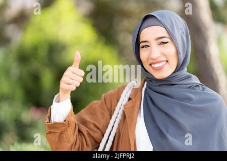 Femme gestante pour être bonne avec le pouce vers le haut à l'extérieur Banque D'Images