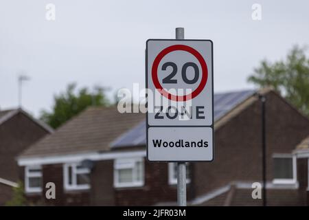 Le panneau de limite de vitesse publique dans la zone urbaine de Harrogate, Royaume-Uni, indique 20 zones Woodlands avec des maisons en arrière-plan Banque D'Images