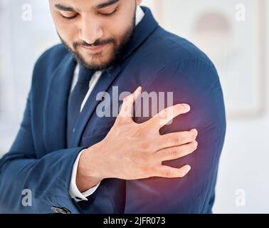 J’ai une douleur soudaine. Photo d'un jeune homme d'affaires tenant son épaule dans la douleur au travail. Banque D'Images
