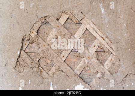 Surface d'un vieux mur en bois recouvert d'un mélange de plâtre d'argile et de planches Banque D'Images