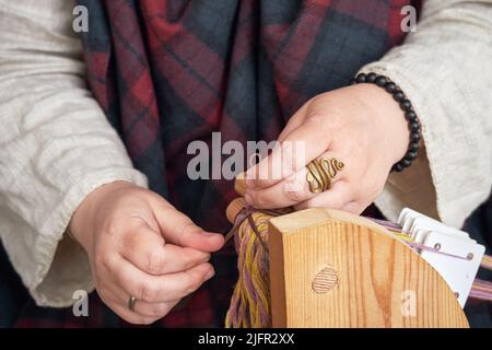 Une ancienne femme romaine fabrique des fils et des ragoûts à partir de laine d'époque. Reconstruction des événements de l'Empire romain Banque D'Images