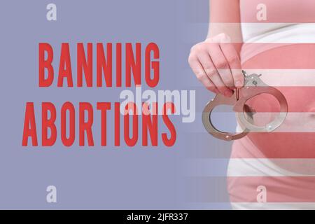 Inscription interdisant l'avortement et femme enceinte avec menottes sur le fond de son estomac Banque D'Images