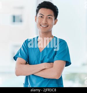 Il s'agit d'être capable et compatissant. Portrait d'un jeune médecin debout avec ses bras croisés dans un hôpital. Banque D'Images