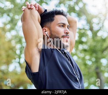 Préparer l'esprit et le corps. Photo d'un jeune homme sportif qui étire les bras tout en s'exerçant à l'extérieur. Banque D'Images