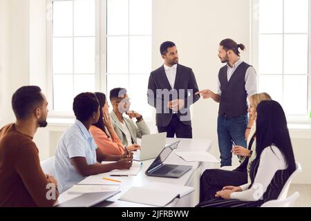 Diverses équipes d'affaires à l'écoute de leur responsable en colère pendant la réunion au bureau Banque D'Images