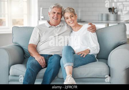 P. S. Je t'aime. Photo d'un heureux couple senior se relaxant sur le canapé à la maison. Banque D'Images