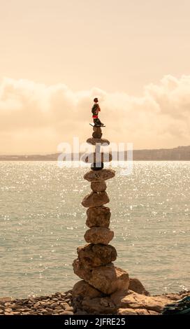 L'art de l'équilibre en pierre dans la belle lumière du coucher de soleil sur la plage. Un grand tas de pierres en parfait équilibre et surtout est placé le St Banque D'Images