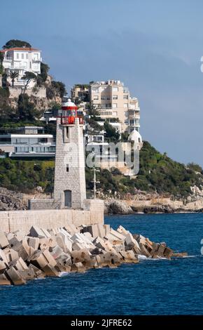 Nice, France, avril 2022. Image verticale du phare, de la mer bleue et du ciel clair, les maisons construites sur la montagne. Banque D'Images