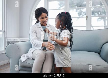 C'est ma chance d'être le médecin maintenant. Photo d'une adorable petite fille jouant avec un stéthoscope lors d'une consultation avec un médecin dans un bureau médical. Banque D'Images