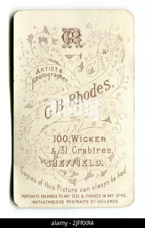 L’inverse d’une photographie victorienne anglaise carte de visite faisant la publicité des services de “G. B. Rhodes, artiste et photographe » (George Booth Rhodes) de « 100 Wicker & 31 Crabtree, Sheffield ». Il affirme également que « des copies de cette photo peuvent toujours être réalisées – des portraits agrandis à toute taille et finis dans n'importe quel style – des portraits instantanés d'enfants ». Vers. 1890s Banque D'Images