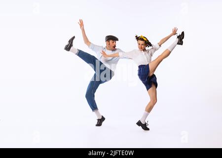 Portrait de beau couple, homme et femme, dansant isolé sur fond blanc de studio. Boogie woogie, torsion Banque D'Images