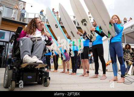 Détenteur de bâton et fondateur du club de boccia en fauteuil roulant de Bristol, Georgina Moore est accueillie par une garde d'honneur de surf alors qu'elle porte le bâton de la Reine à la vague de Bristol. Le relais Queen's Baton est arrivé à Bristol , pendant la dernière étape de son voyage de 2 500 miles aux Jeux du Commonwealth de Birmingham 2022. Date de la photo: Mardi 5 juillet 2022. Banque D'Images