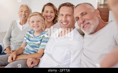 Portrait d'une famille de caucasiens de génération heureuse prenant des selfies à la maison. Un petit garçon se détendant et se liant avec des parents et des grands-parents insouciants pendant Banque D'Images