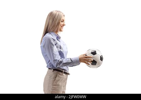 Photo de profil d'une femme vêtue d'un vêtement habillé tenant un ballon de football isolé sur fond blanc Banque D'Images