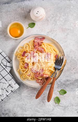 Pâtes Carbonara. Spaghetti à la pancetta, aux œufs, au parmesan et à la crème sur fond de table en béton gris. Cuisine italienne traditionnelle et Banque D'Images