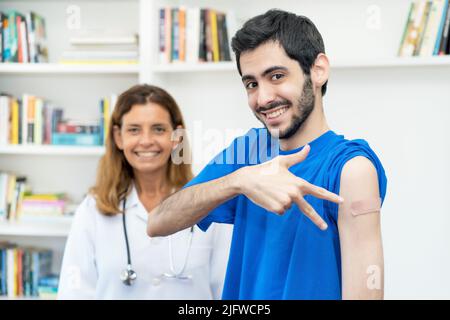 Jeune arabe après troisième vaccination contre Covid 19 avec une infirmière à l'hôpital Banque D'Images